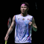 A high-action shot of Lee Zii Jia mid-smash on the badminton court, wearing the Malaysian national team jersey during the 2026 Thomas Cup.