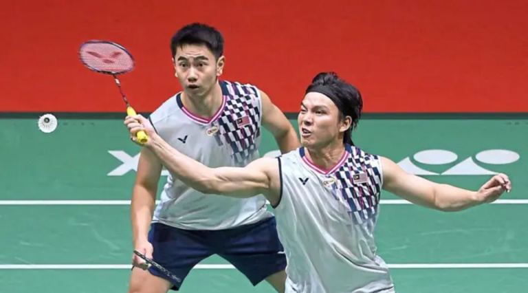 Malaysian men's doubles pair Goh Sze Fei and Nur Izzuddin Rumsani in action on the badminton court, mid-rally during their Thomas Cup match against Finland.