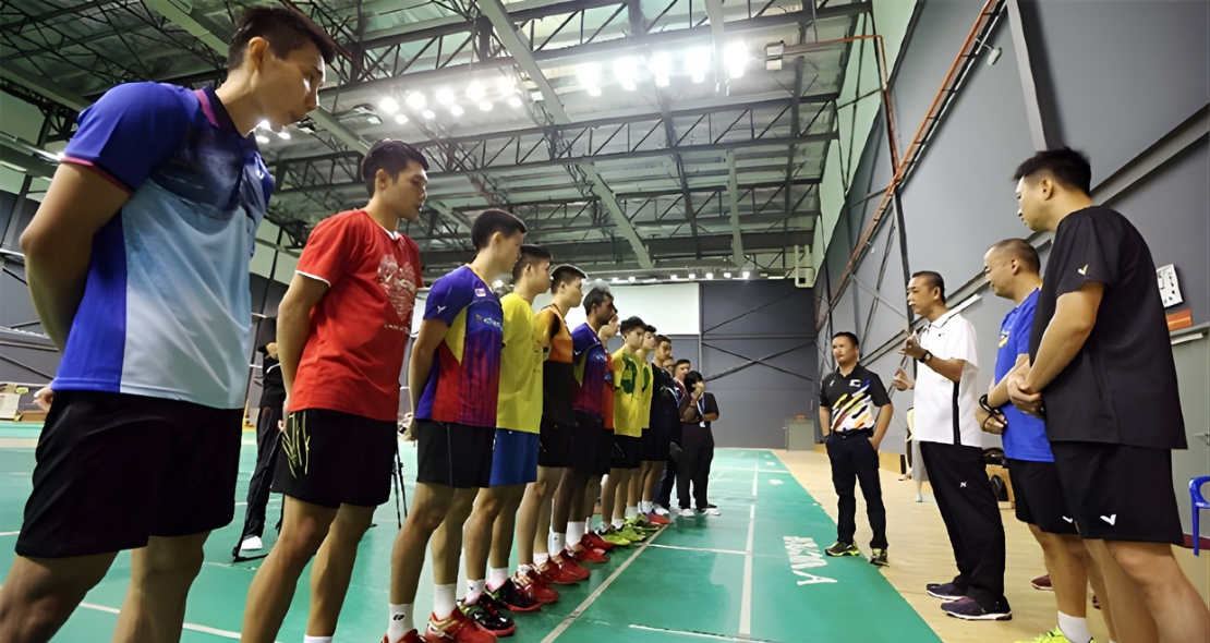 Malaysian national team players listen to coach during intensive training session