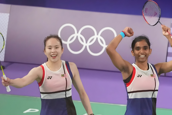 Uber Cup 2026 Campaign stars Pearly Tan and M Thinaah celebrating a win in front of the Olympic rings.
