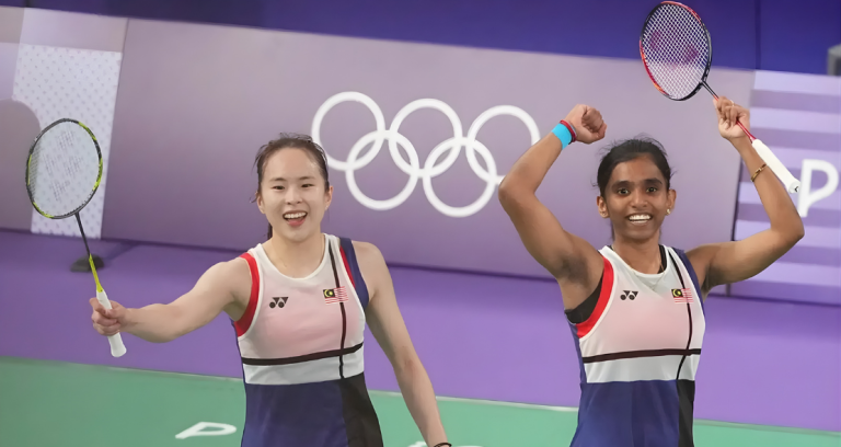 Uber Cup 2026 Campaign stars Pearly Tan and M Thinaah celebrating a win in front of the Olympic rings.