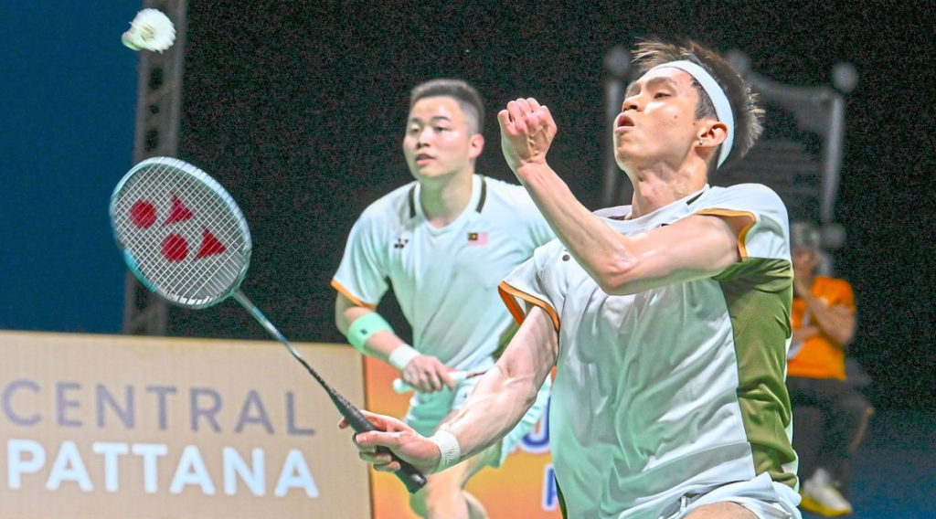 Close-up of Aaron Chia and Soh Wooi Yik in their official Malaysia team jerseys, looking focused and determined on the badminton court during the Thomas Cup 2026.