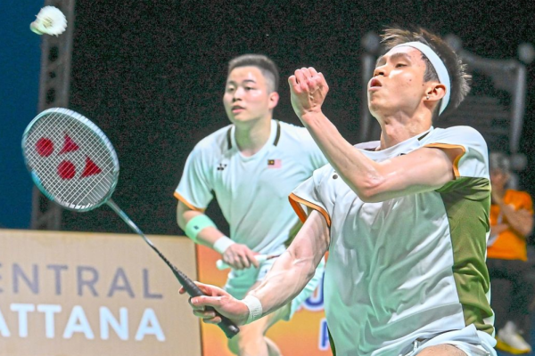 Close-up of Aaron Chia and Soh Wooi Yik in their official Malaysia team jerseys, looking focused and determined on the badminton court during the Thomas Cup 2026.
