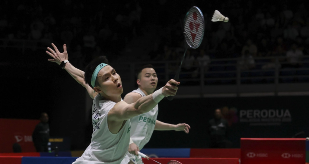 BWF World Rankings Shift context featuring Aaron Chia and Soh Wooi Yik defending a low shot.