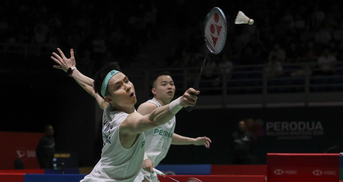 BWF World Rankings Shift context featuring Aaron Chia and Soh Wooi Yik defending a low shot.