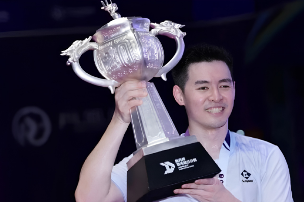 June Wei Taiwan Open showing Cheam June Wei holding the giant silver Lin Dan Cup trophy after his victory.