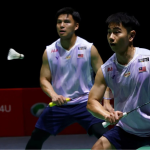 Sze Fei-Izzuddin Japan Open match showing Goh Sze Fei lunging forward with Nur Izzuddin tracking the shuttlecock.