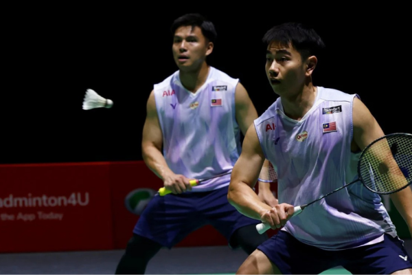 Sze Fei-Izzuddin Japan Open match showing Goh Sze Fei lunging forward with Nur Izzuddin tracking the shuttlecock.