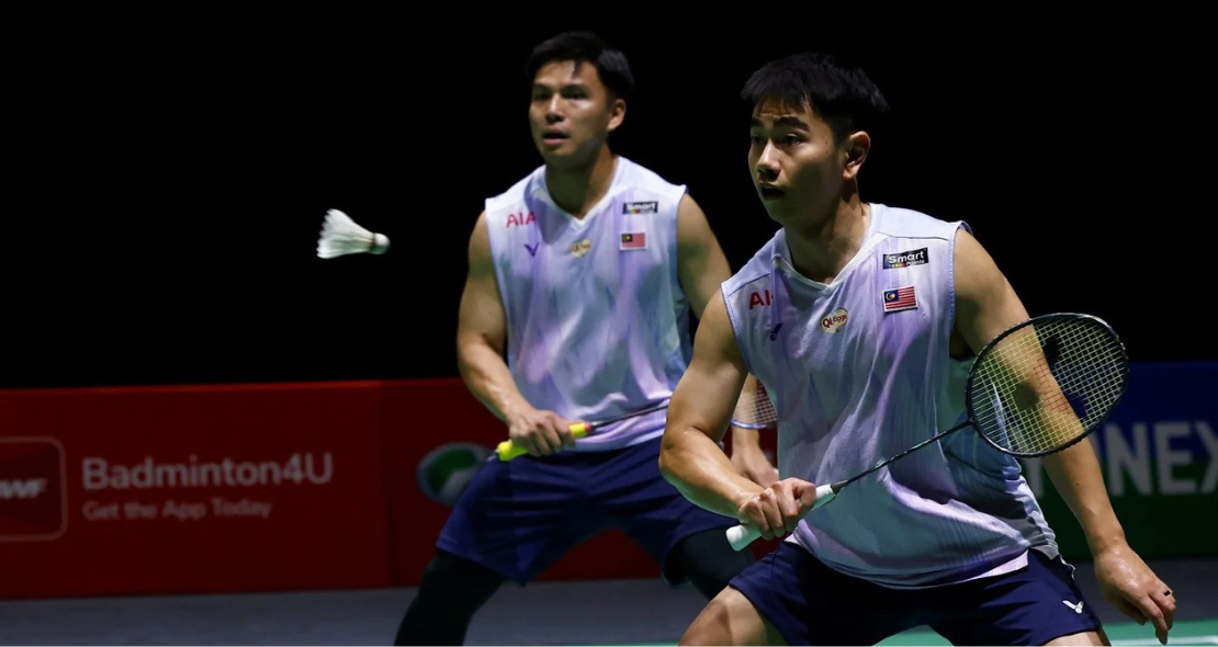 Sze Fei-Izzuddin Japan Open match showing Goh Sze Fei lunging forward with Nur Izzuddin tracking the shuttlecock.