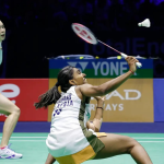 Pearly-Thinaah court defense showing M Thinaah lunging extremely low to return a shuttlecock on the green court.