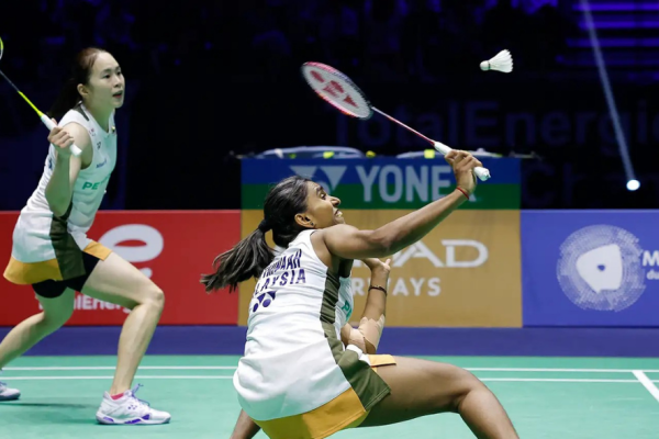 Pearly-Thinaah court defense showing M Thinaah lunging extremely low to return a shuttlecock on the green court.