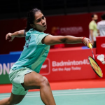 Letshanaa Japan Open match showing K Letshanaa lunging forward to hit the shuttlecock.
