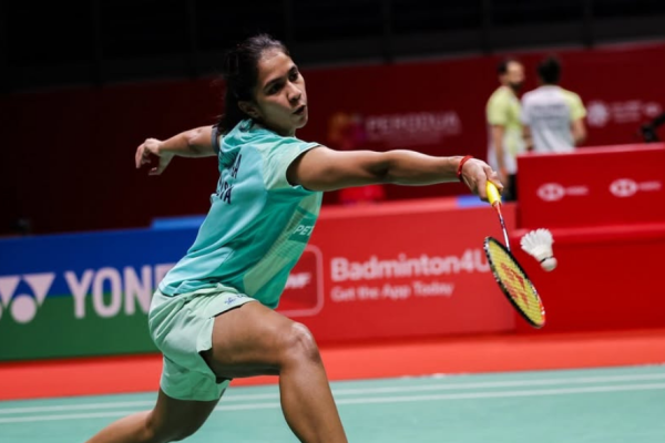Letshanaa Japan Open match showing K Letshanaa lunging forward to hit the shuttlecock.