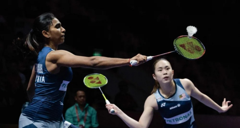 Pearly-Thinaah Taiwan Open showing M Thinaah extending her racket and Pearly Tan crouching low during a match.