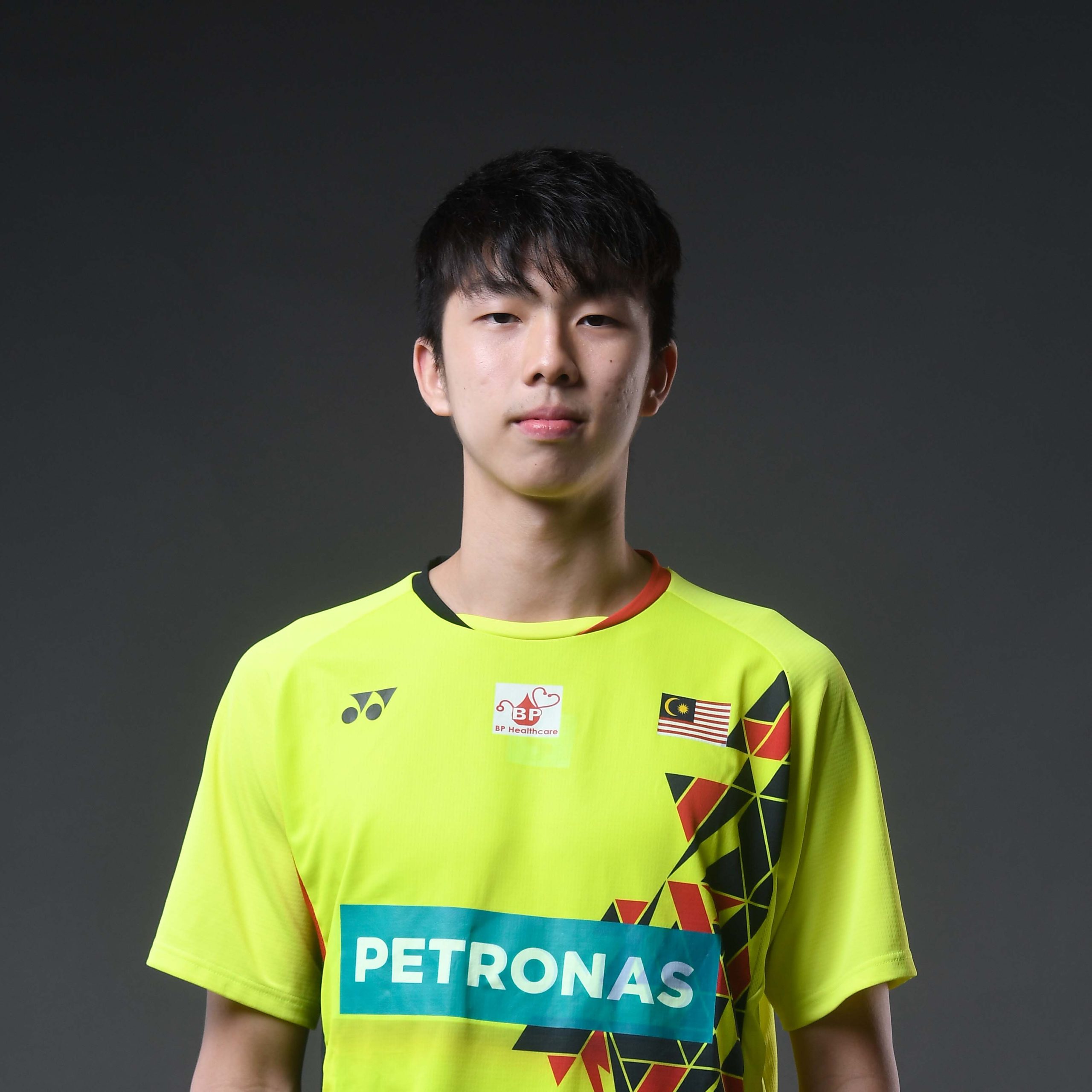 Eogene Ewe professional badminton profile image showing the young Malaysian singles player in his national green Petronas training kit.