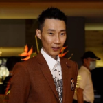 Lee Chong Wei professional badminton profile image showing the legendary Malaysian badminton icon posing in a brown suit.