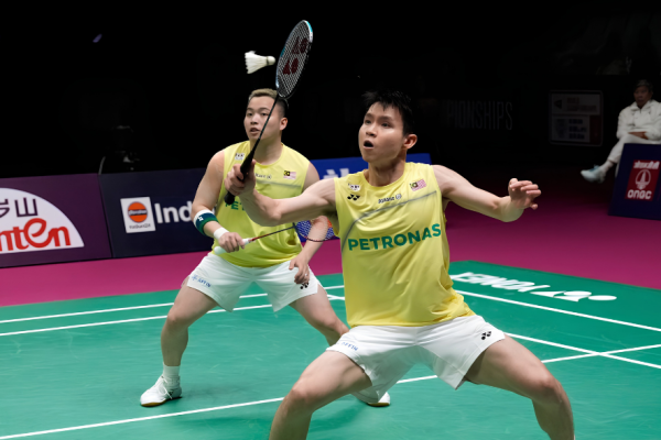 Aaron-Wooi Yik Worlds Final showing Soh Wooi Yik crouching low at the net with Aaron Chia watching in the background.