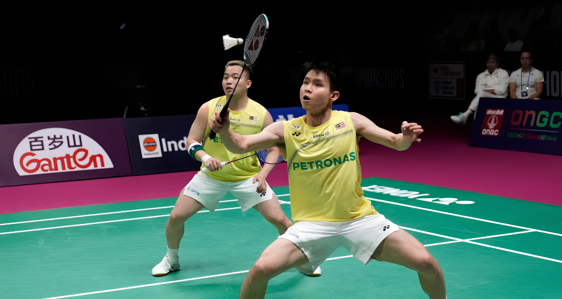 Aaron-Wooi Yik Worlds Final showing Soh Wooi Yik crouching low at the net with Aaron Chia watching in the background.