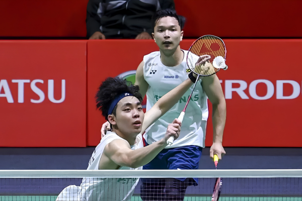 Arif-Roy King Victory showing Yap Roy King lunging near the net with Wan Arif Junaidi watching in the background.