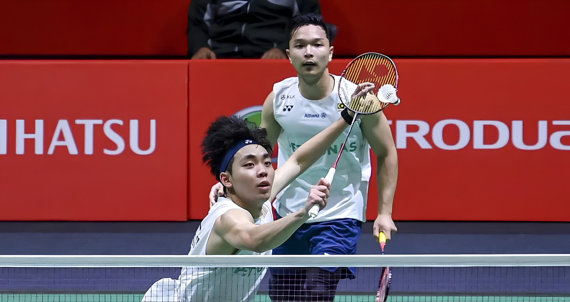 Arif-Roy King Victory showing Yap Roy King lunging near the net with Wan Arif Junaidi watching in the background.