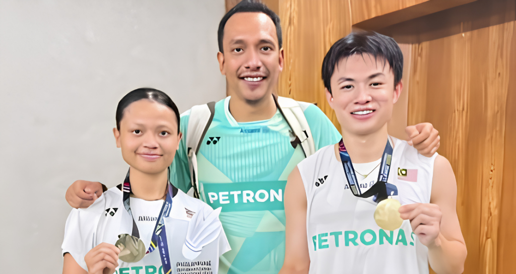 Dania-Boon Zhe Manila Title showing Dania Sofea Zaidi, coach Hazwan Jamaluddin, and Goh Boon Zhe posing with their trophy and winner's check.