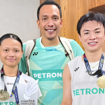 Dania-Boon Zhe Manila Title showing Dania Sofea Zaidi, coach Hazwan Jamaluddin, and Goh Boon Zhe posing with their trophy and winner's check.