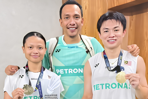 Dania-Boon Zhe Manila Title showing Dania Sofea Zaidi, coach Hazwan Jamaluddin, and Goh Boon Zhe posing with their trophy and winner's check.