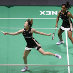 Pearly-Thinaah Shenzhen Campaign showing Pearly Tan lunging low on court with M Thinaah watching in the background.
