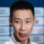 Lee Chong Wei speaks to journalists during a media interview in front of a tournament sponsor backdrop