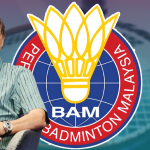 Razif Sidek speaks into a microphone during an interview beside the Badminton Association of Malaysia logo.