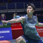Eogene Ewe lunges forward to execute a backhand net shot in his teal Petronas Malaysian national jersey.