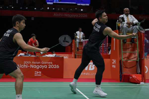 Nur Izzuddin Rumsani executes a forehand net tap while Goh Sze Fei stays ready during the Asian Games men's doubles match.