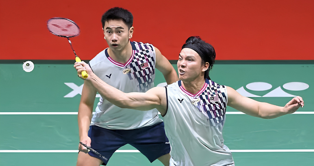 Goh Sze Fei and Nur Izzuddin Rumsani track the shuttlecock intently in their white Malaysian jerseys during a match.