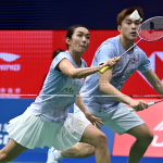 Lai Pei Jing lunges low at the net while Hoo Pang Ron tracks the shuttlecock in their light blue Malaysian kits.
