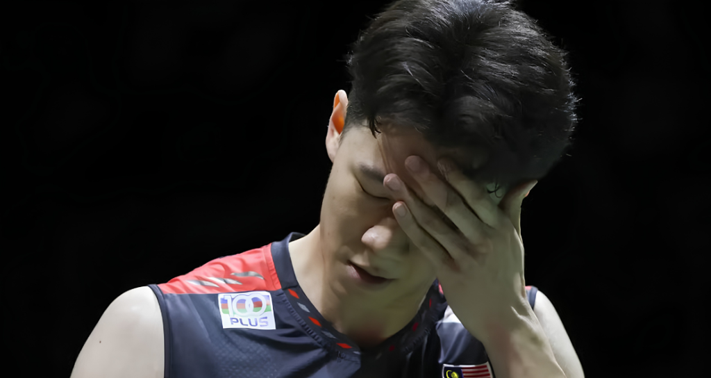 Lee Zii Jia covers his face in disappointment wearing his Malaysian national team jersey after a tough match.