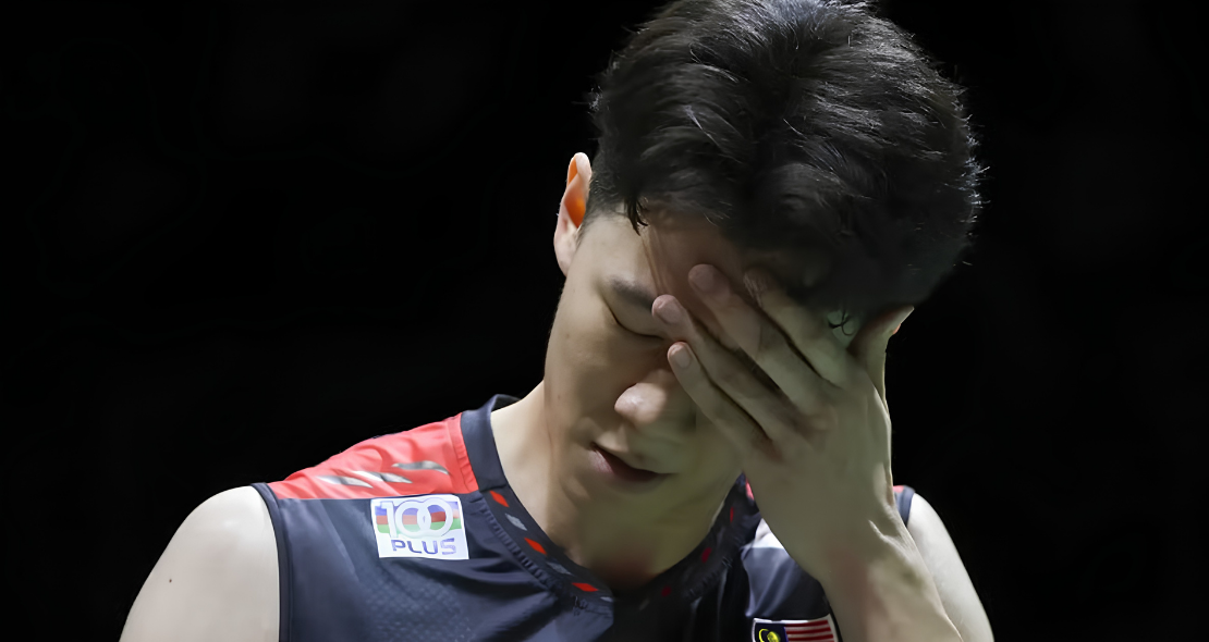 Lee Zii Jia covers his face in disappointment wearing his Malaysian national team jersey after a tough match.