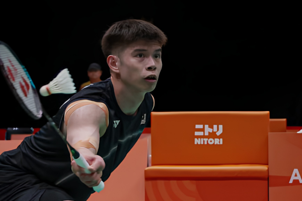 Leong Jun Hao lunges low to play a forehand net shot in his black Malaysian jersey during the Asian Games.