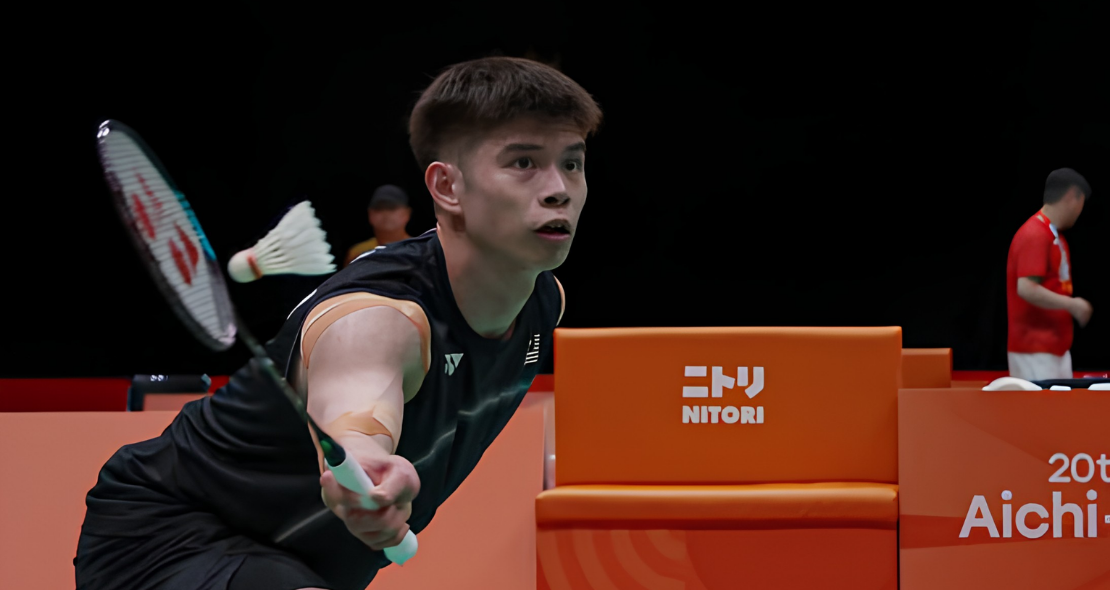 Leong Jun Hao lunges low to play a forehand net shot in his black Malaysian jersey during the Asian Games.