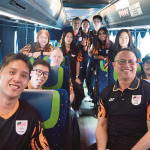 Rexy Mainaky and Malaysian national badminton players smile together inside the team bus during their Asian Games journey.