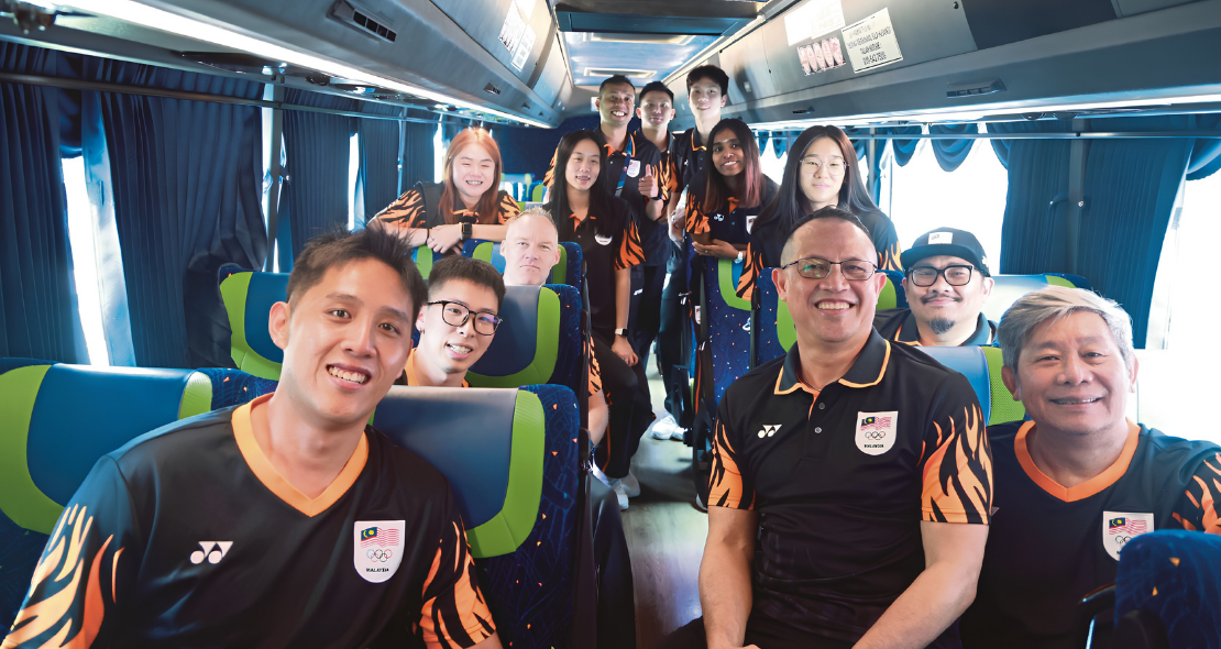 Rexy Mainaky and Malaysian national badminton players smile together inside the team bus during their Asian Games journey.