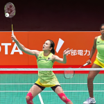 Pearly Tan intercepts the shuttlecock at the net while M. Thinaah guards the rear court in their lime green jerseys during the Asian Games quarterfinal against South Korea.