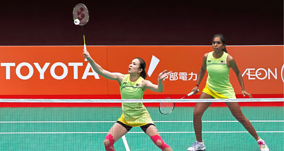 Pearly Tan intercepts the shuttlecock at the net while M. Thinaah guards the rear court in their lime green jerseys during the Asian Games quarterfinal against South Korea.