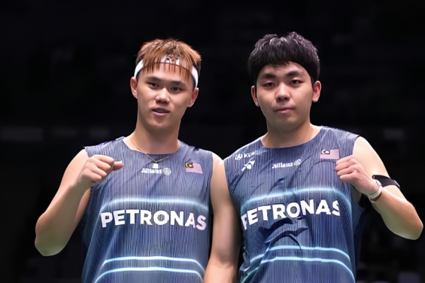 Tee Kai Wun and Yap Roy King celebrate with fist pumps in their navy blue Petronas Malaysian national team jerseys.