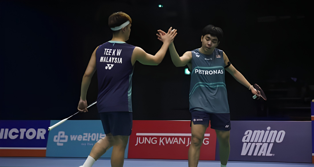 Tee Kai Wun and Yap Roy King exchange a high five on court while celebrating a point in their Malaysian national jerseys.