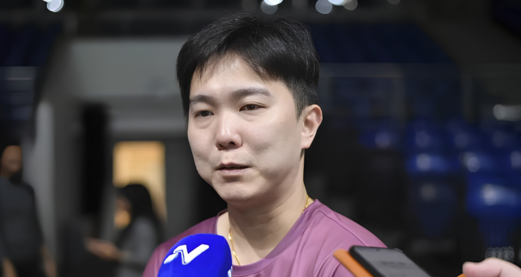Teo Kok Siang speaks to journalists during a media interview in his maroon shirt inside the stadium.