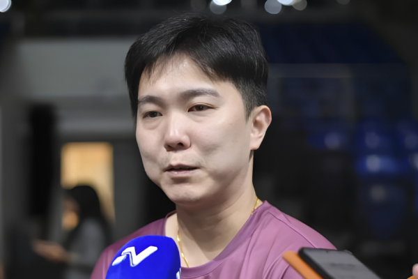 Teo Kok Siang speaks to journalists during a media interview in his maroon shirt inside the stadium.