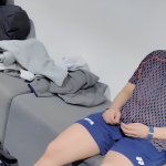 Toh Ee Wei rests on a bench in her training jersey and blue shorts during a post-workout recovery session.