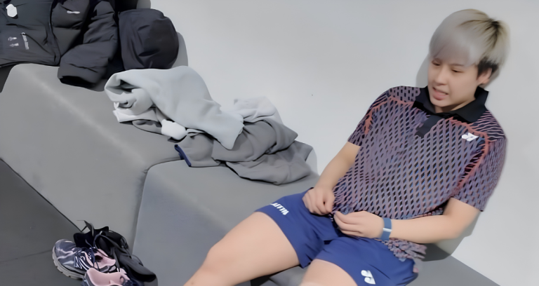 Toh Ee Wei rests on a bench in her training jersey and blue shorts during a post-workout recovery session.