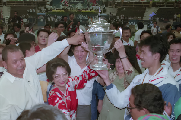 Dr Siti Hasmah Mohamad Ali lifts the 1992 Thomas Cup trophy alongside team captain Razif Sidek and the Malaysian squad.