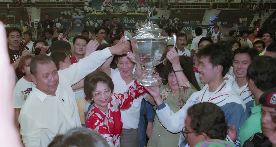 Dr Siti Hasmah Mohamad Ali lifts the 1992 Thomas Cup trophy alongside team captain Razif Sidek and the Malaysian squad.